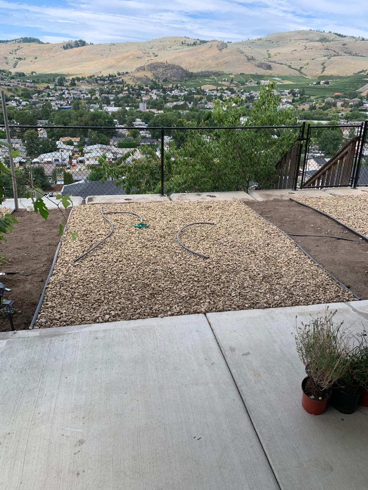 After: backyard fully covered in crushed gravel with drip irrigation, valley view